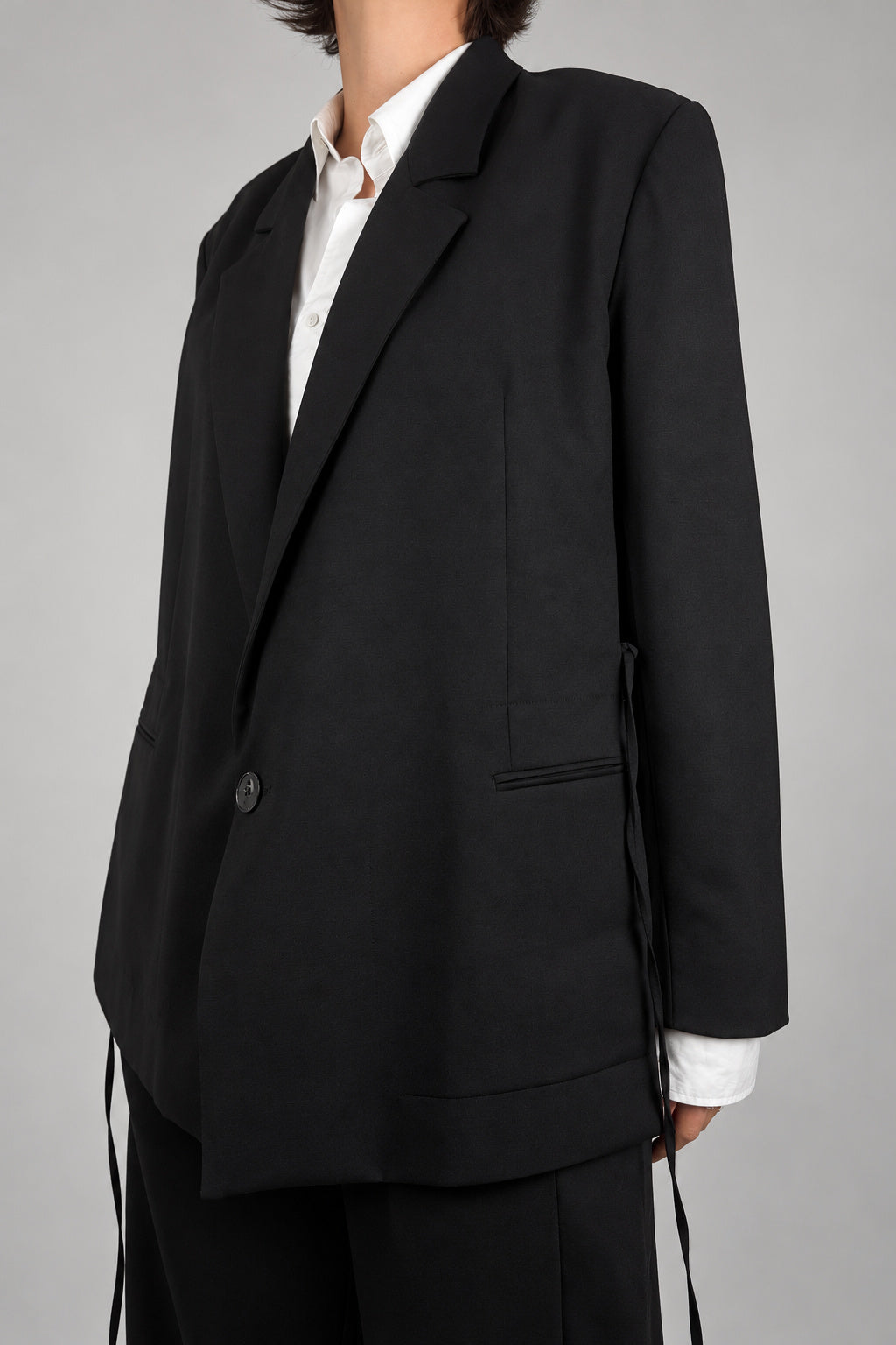 Open Side Blazer in black, side detail with the straps hanging loose - Maison Marron et amis