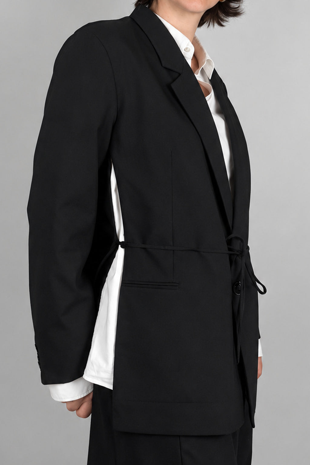 Open Side Blazer in black, detail of the open side seam with the white shirt underneath - Maison Marron et amis