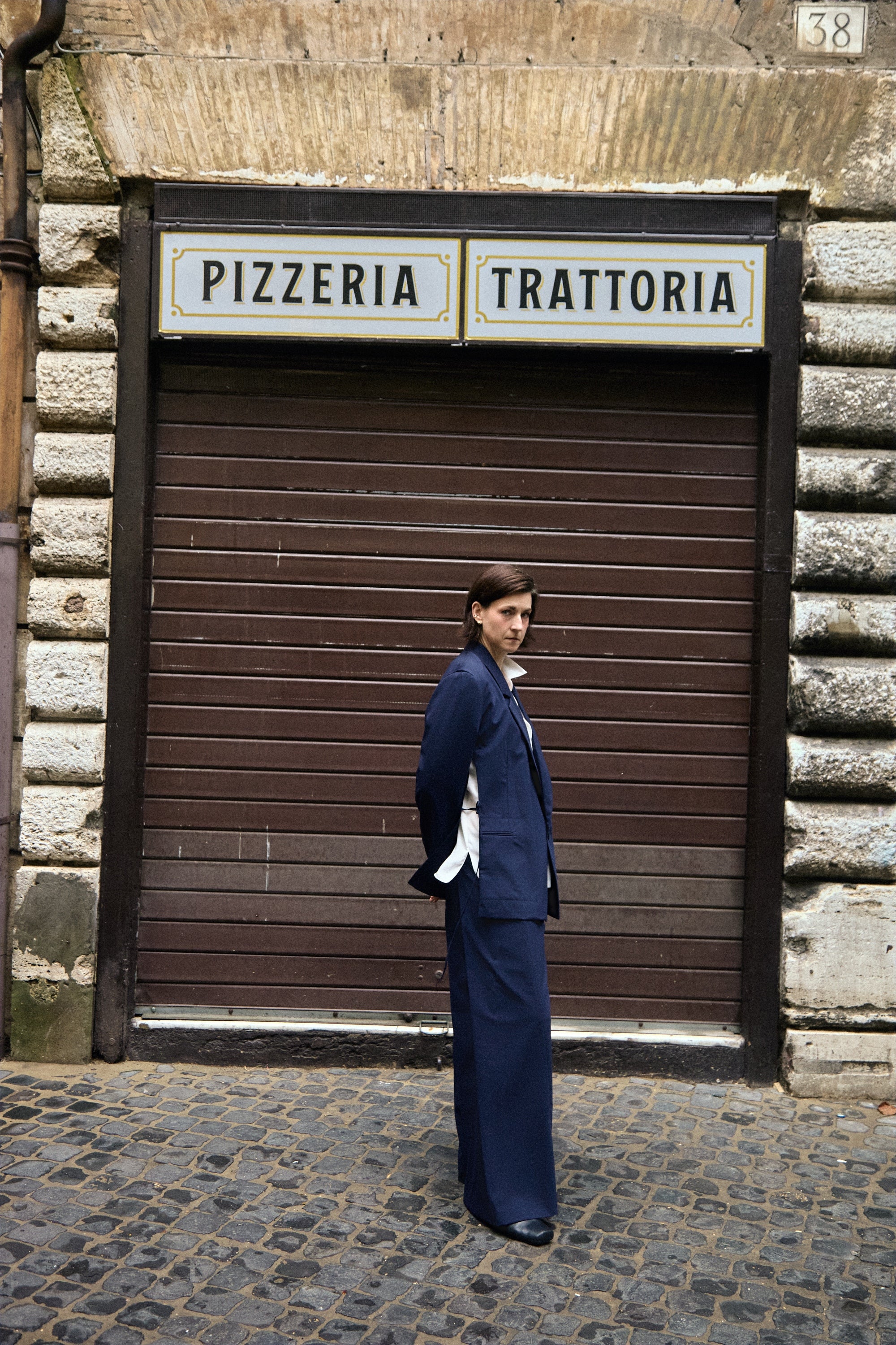 Open Side Blazer in navy, side view in front of a shutter - Maison Marron et amis