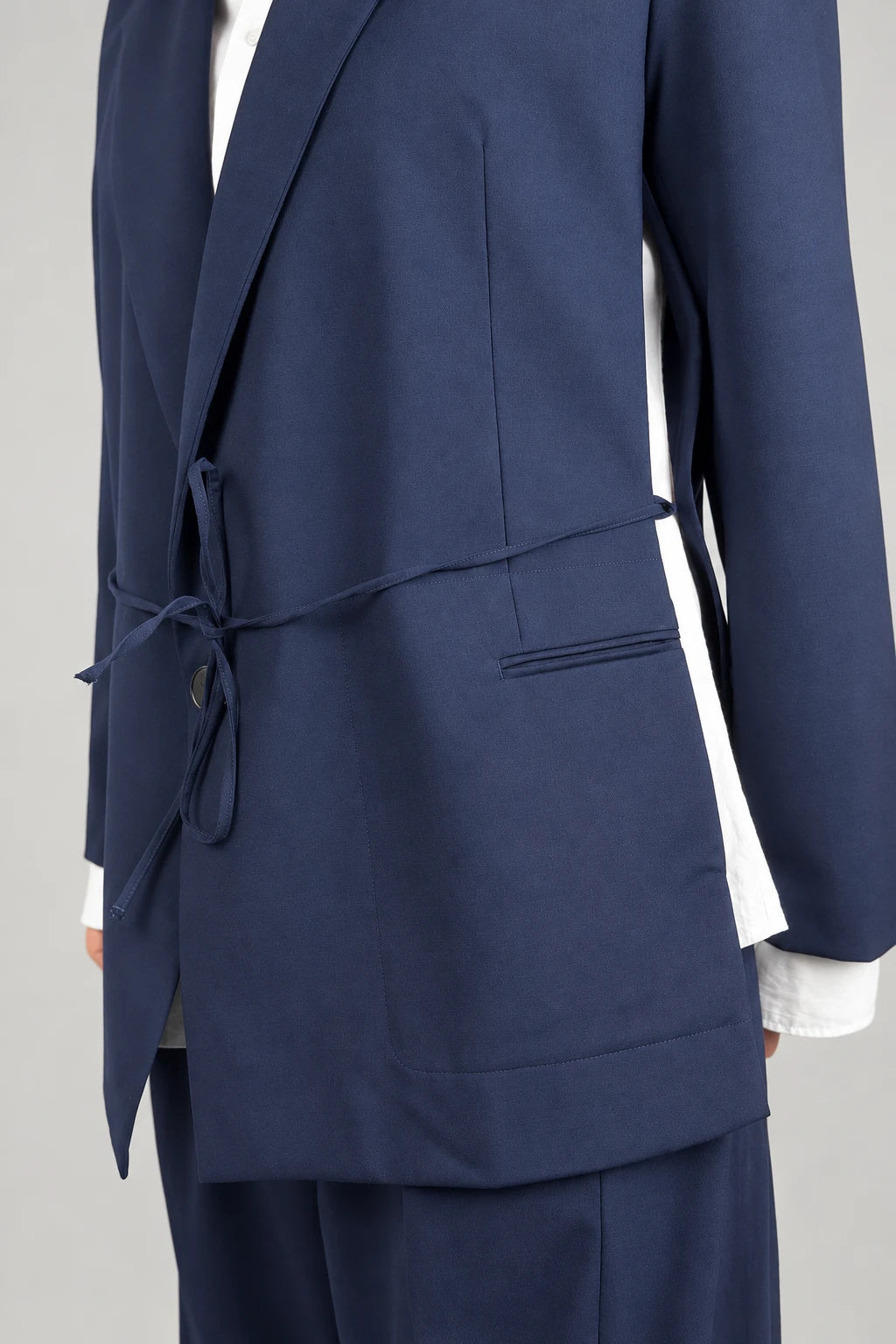 Open Side Blazer in navy, detail of the waist strap and open side seam - Maison Marron et amis
